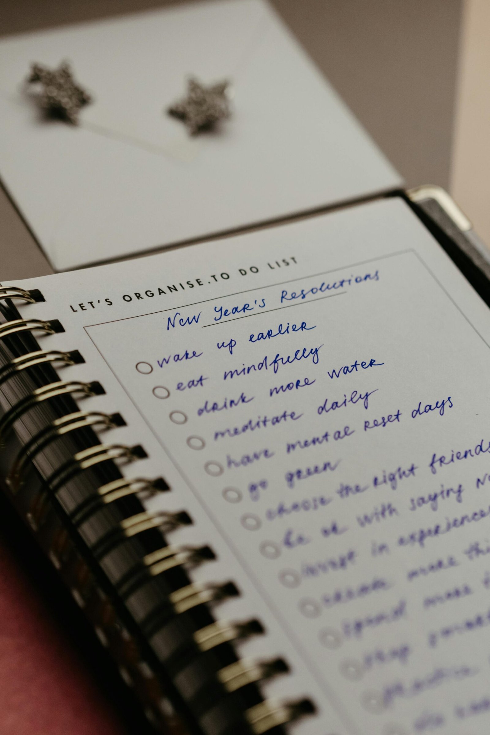 Close-up of a notebook with handwritten New Year's resolutions, organized neatly for planning.